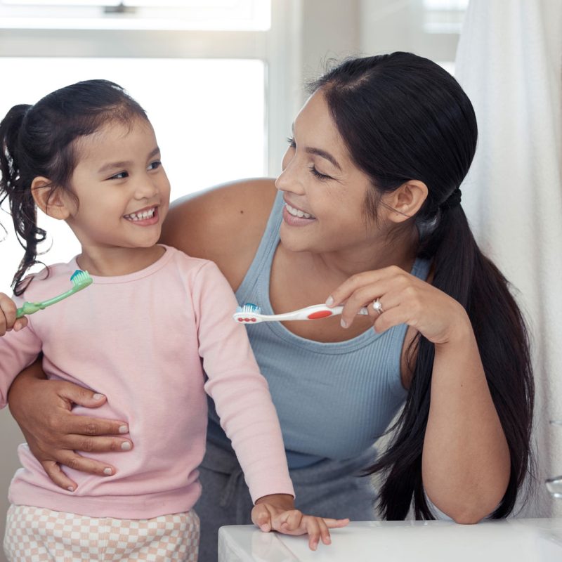 mother and daughter brushing teeth